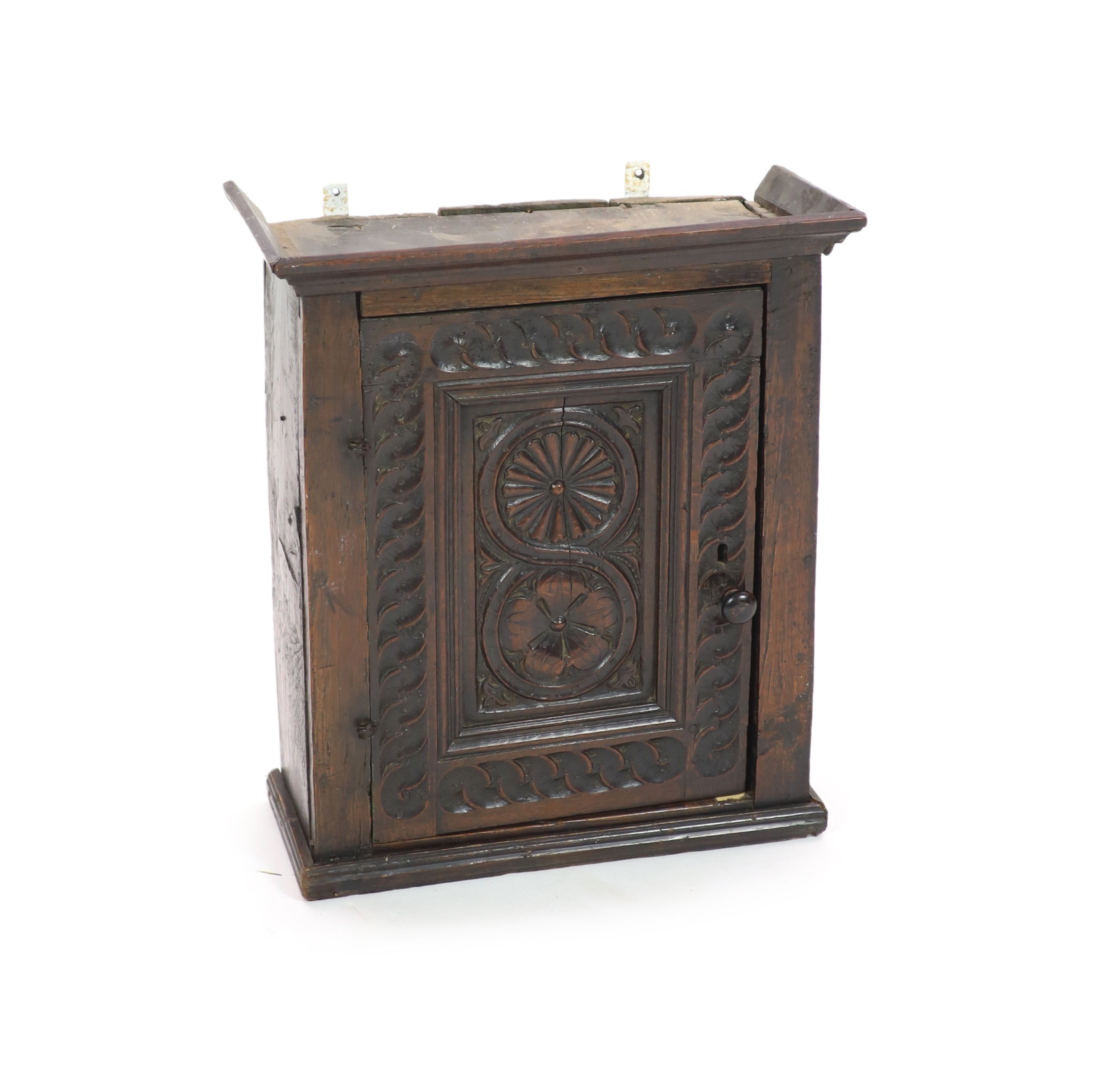 A 17th century carved oak wall cupboard, H 56cm. W 49cm. D 22cm.